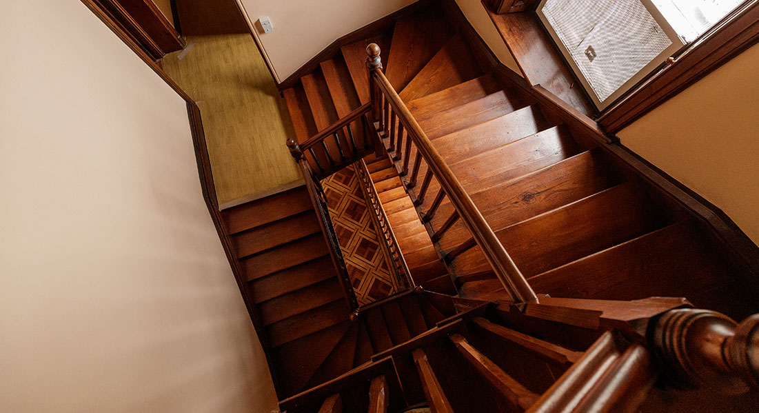 A vertigo-inducing look down twisting wood stair cases to a parquet floor several floors below.